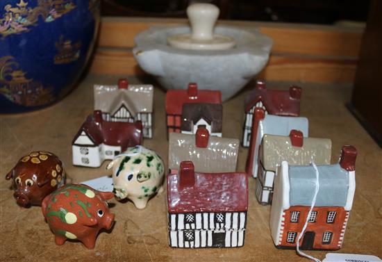 Ten miniature china cottages and three pottery pigs & marble mortar(-)